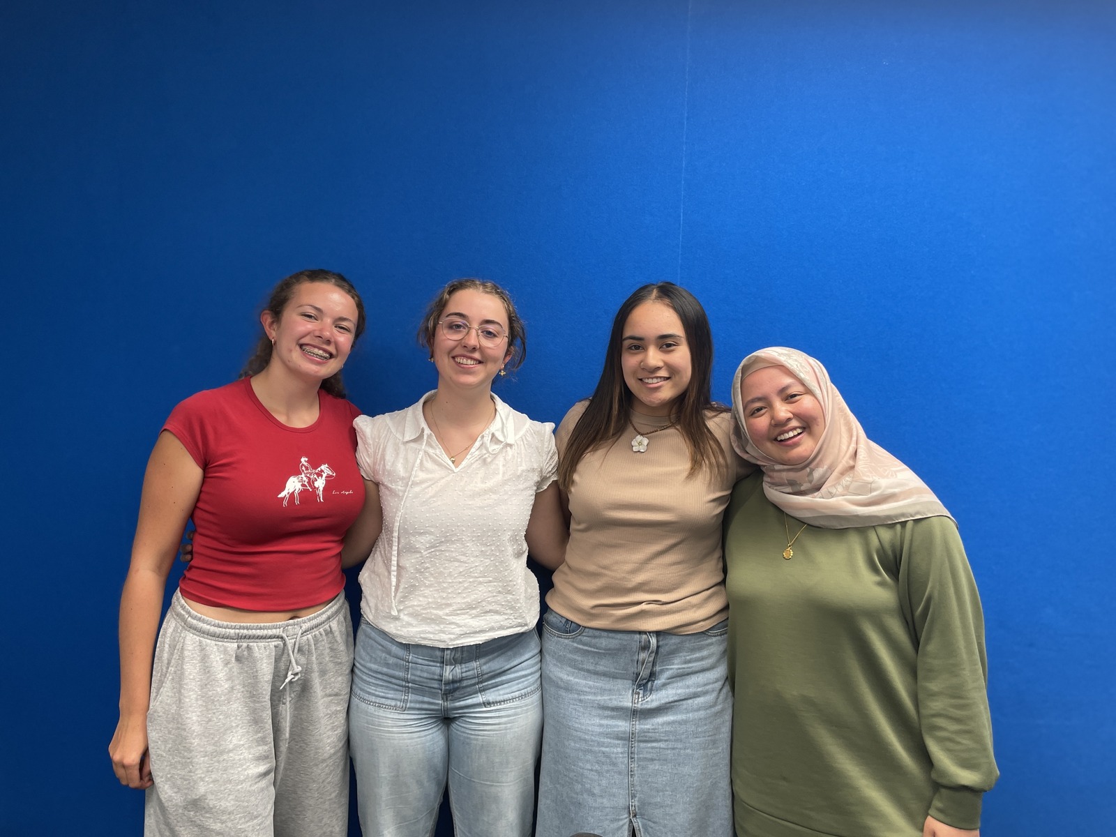 Four people in front of blue studio wall