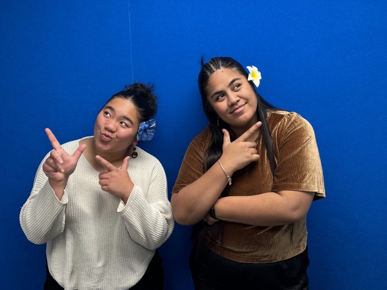 Vika and Meleitia posing in front of blue wall