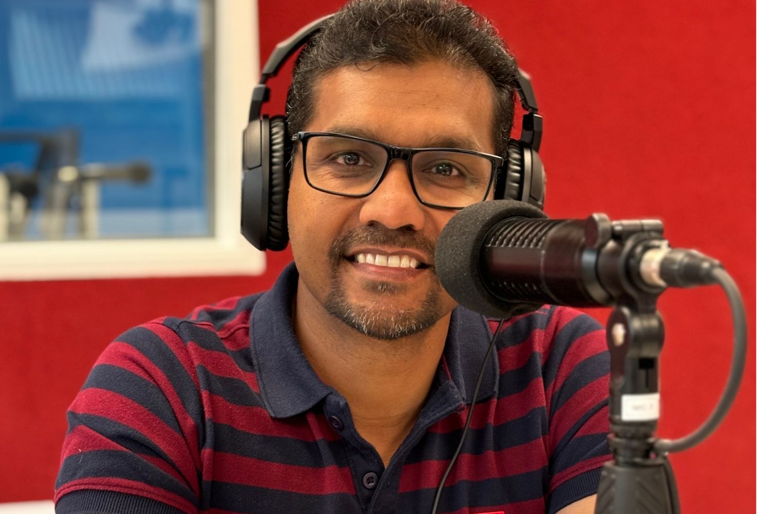 Suranga Dassanayake in live studio in front of a microphone. Host of Sathsara Rāwa