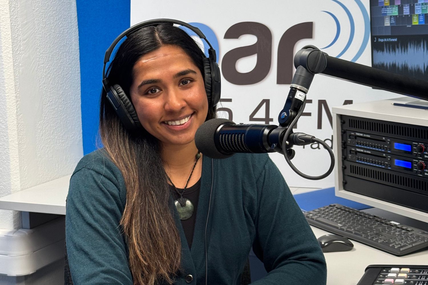 A photo of Namrata Chand from Nana Nature in the OAR FM studios infront of a microphone.