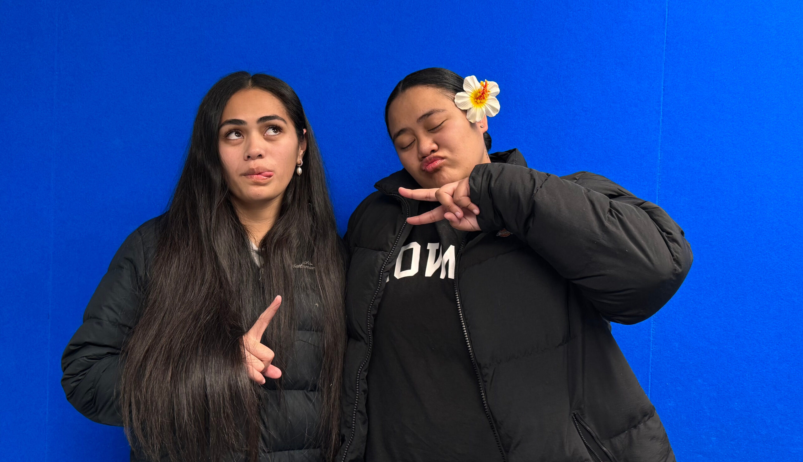 Two broadcasters from OARFM Tafa and Shekinah of Otago Samoan Students Association behind a blue wall.