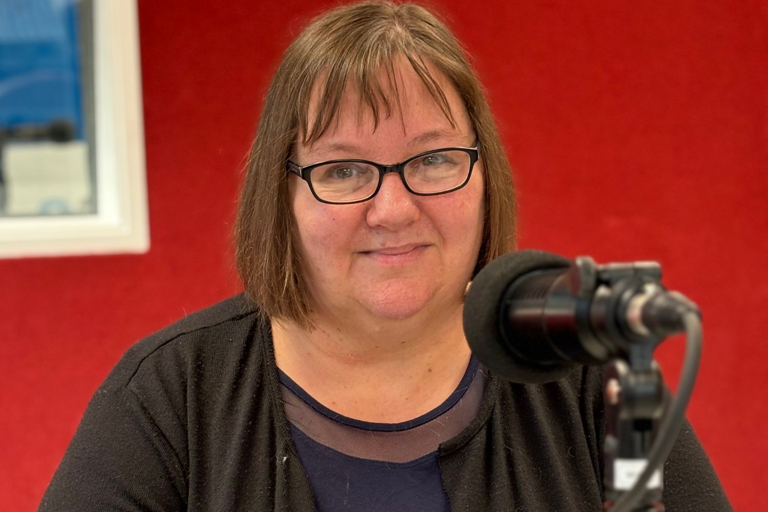 Photo of Krissy Wright in the recording studio in front of a microphone