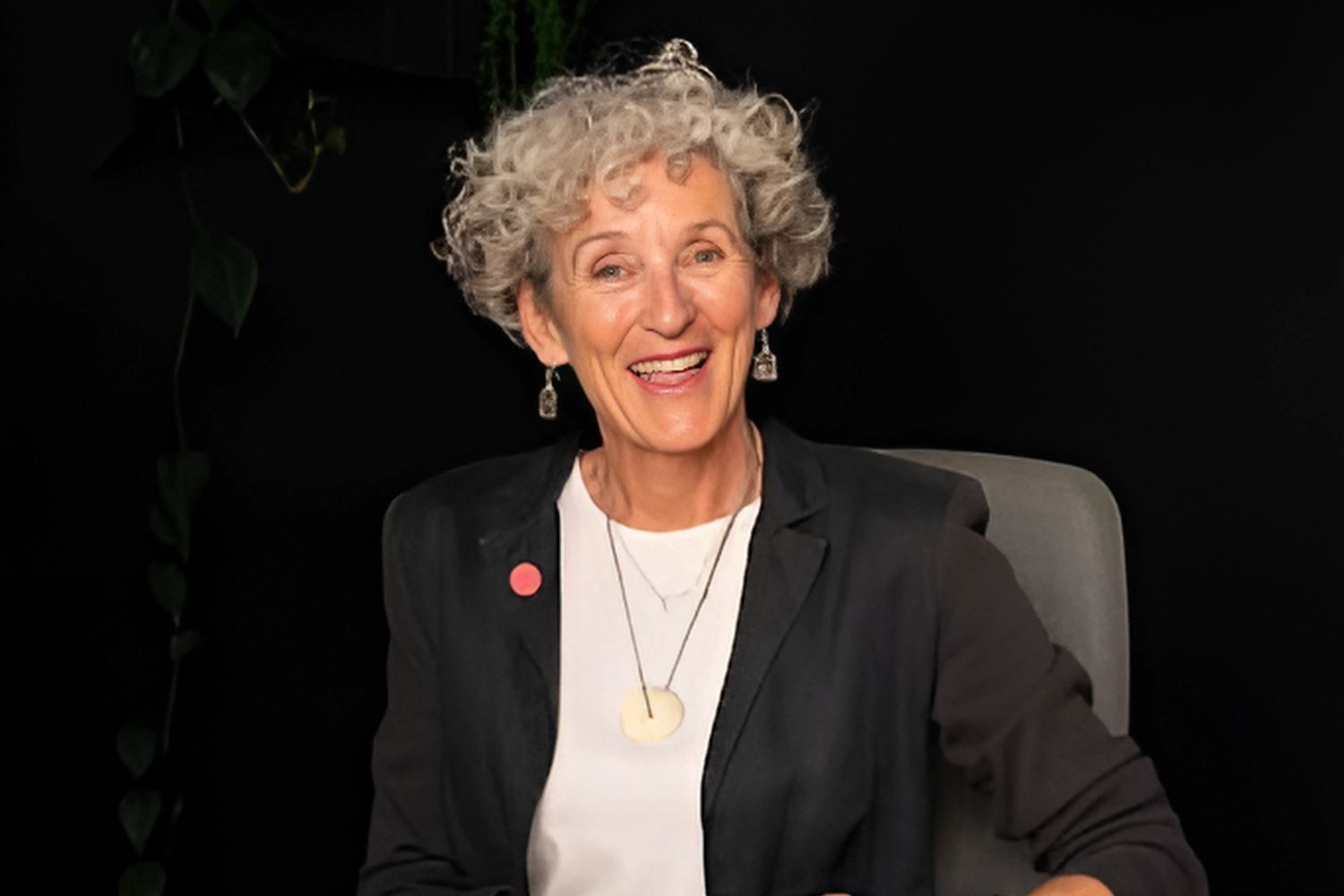 Photo of host Denise Quinlan sitting at a desk