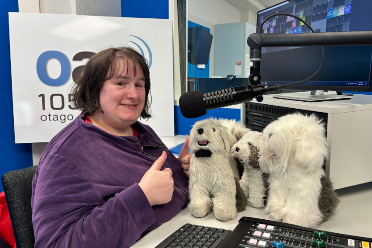 Julia Young in the OAR FM studios with three plush toys of dogs