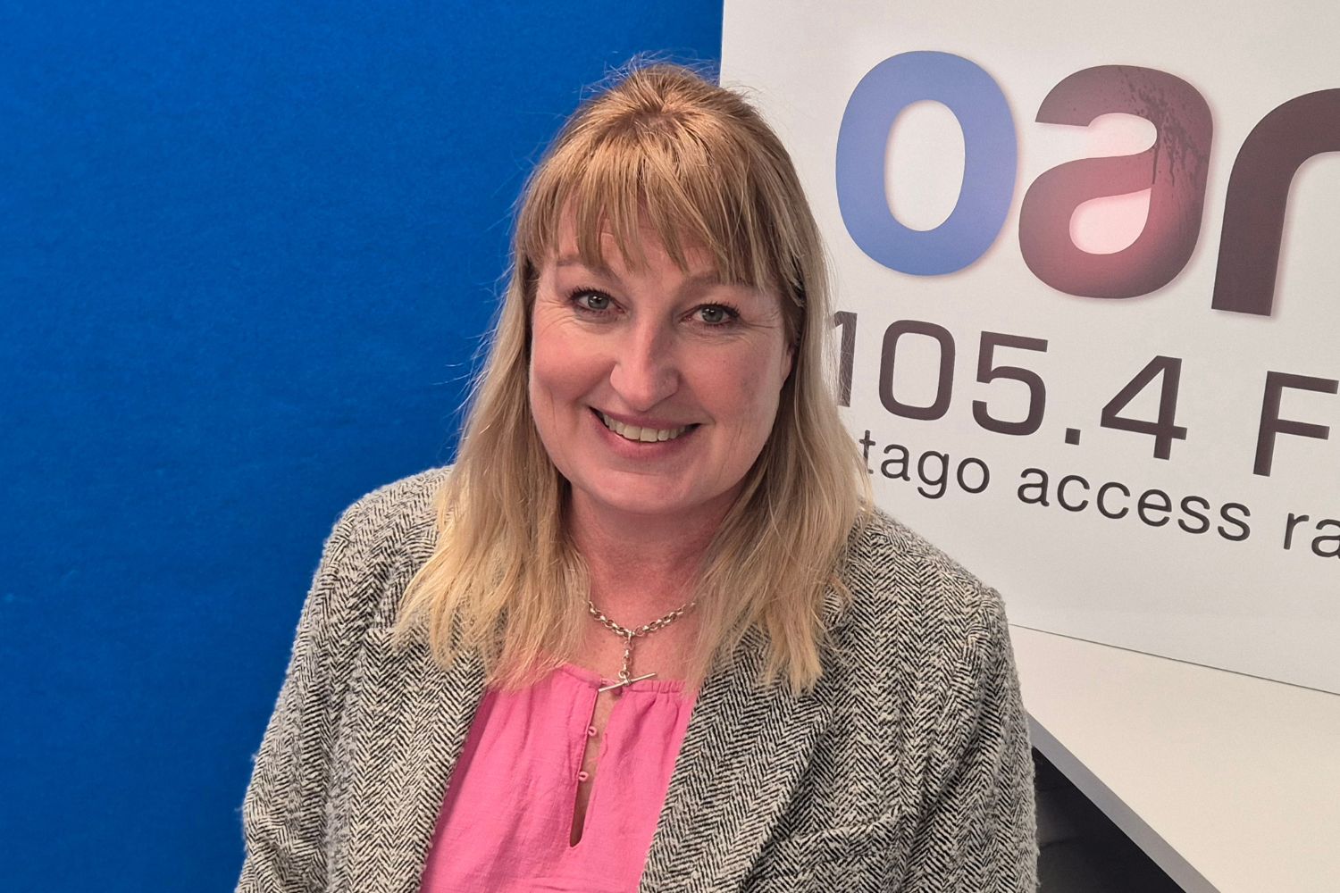 Photo of Antoinette McLean in front of an OAR FM Sign