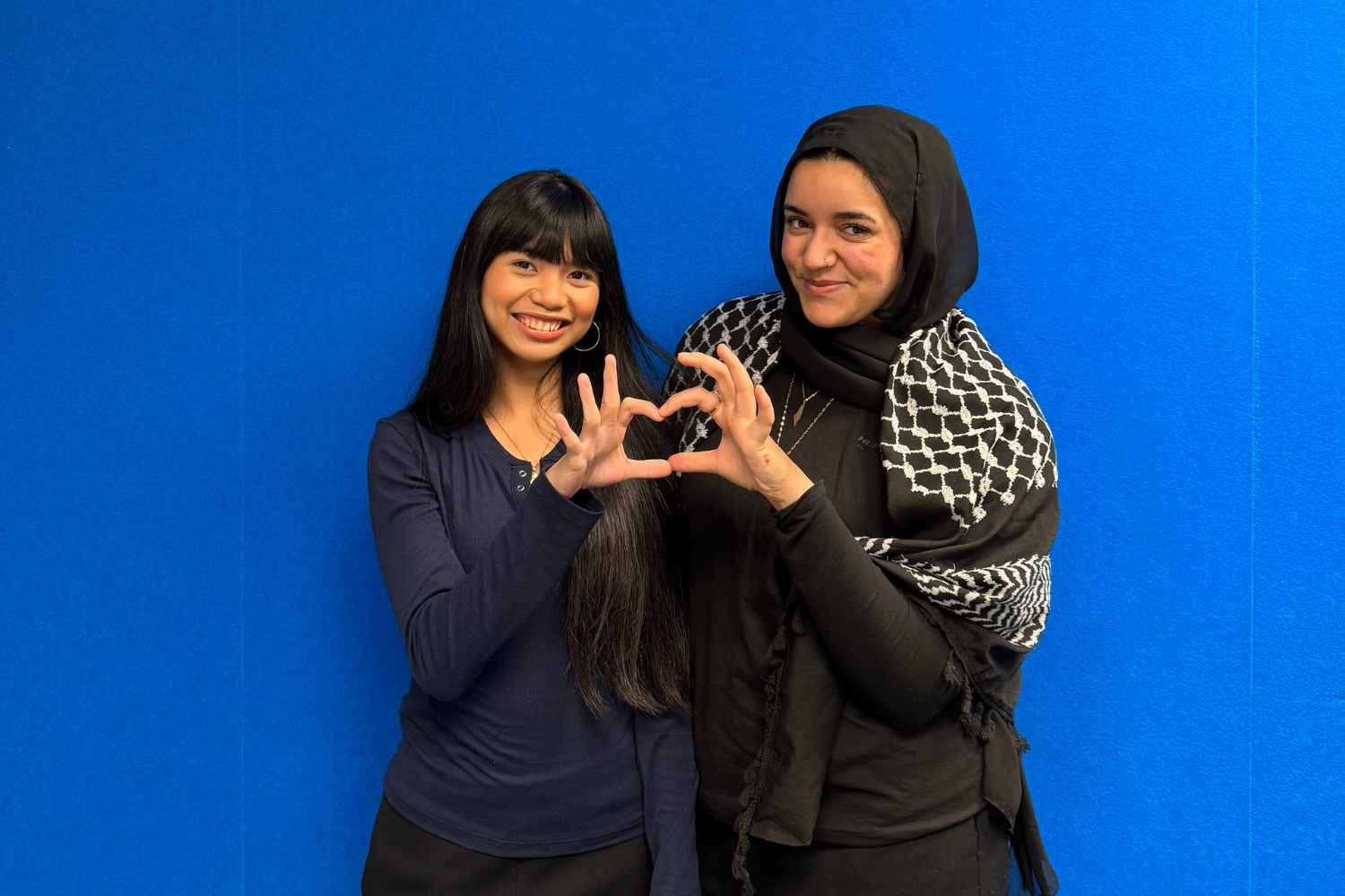 Malak Tamimi and Betty Pagulayan from Unboxed Identities pose infront of a blue wall.