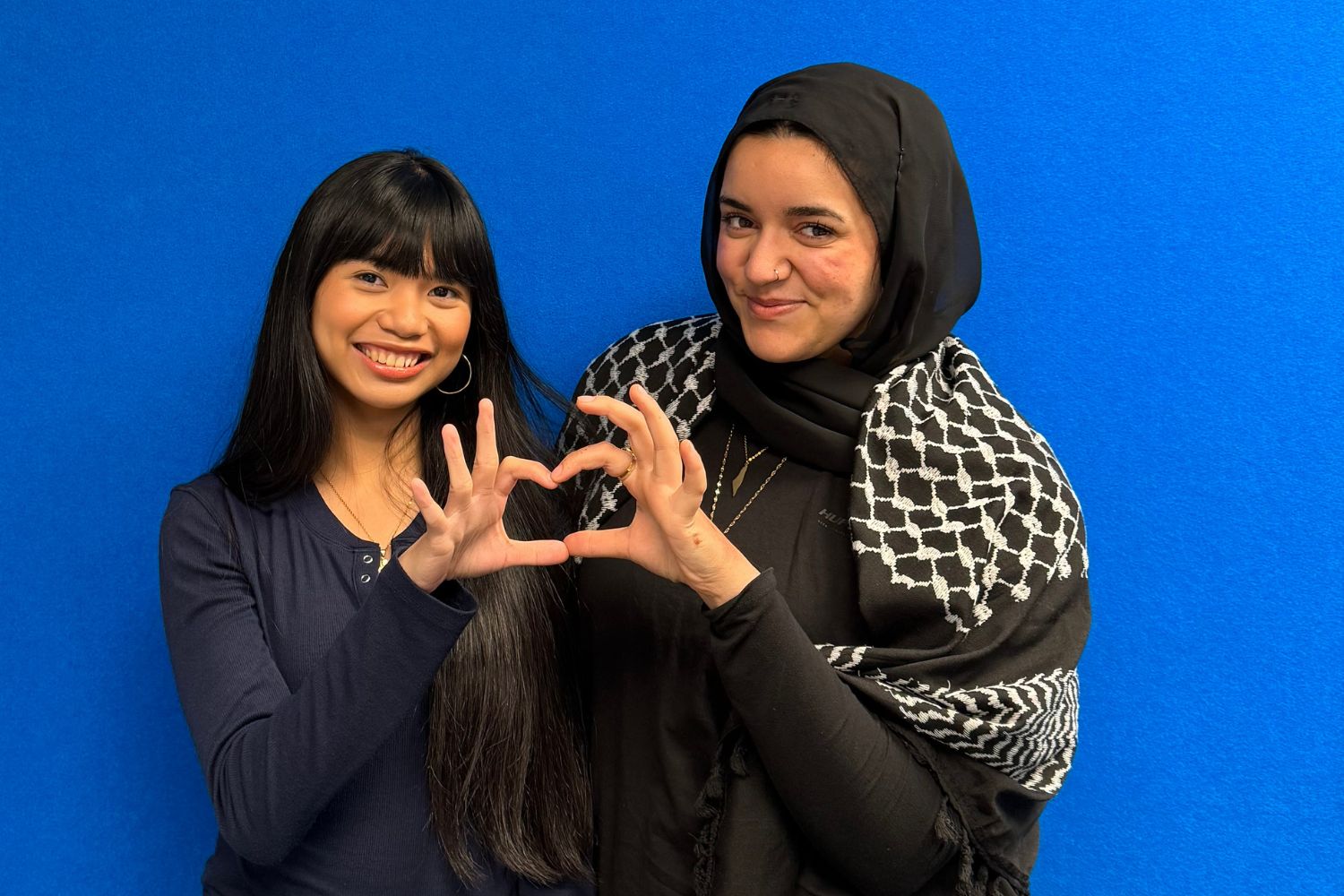 Malak Tamimi and Betty Pagulayan from Unboxed Identities pose infront of a blue wall.