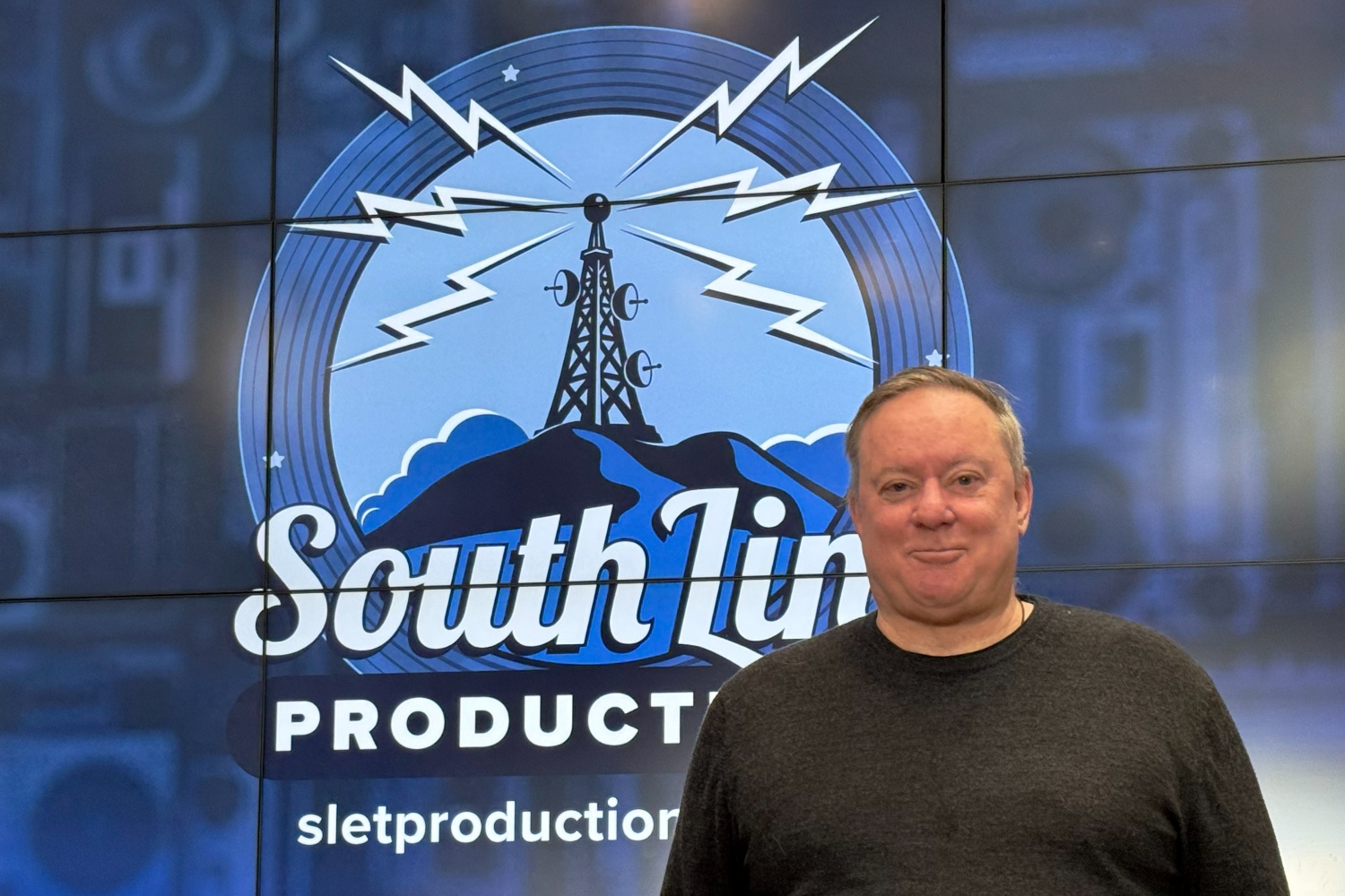 Photo of Nick Roughan in front of a blue South Link Productions sign